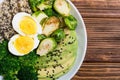 Buddha bowl with quinoa eggs , avocado , brussels sprouts and broccoli . Food vegan salad on wooden backgground
