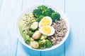 Buddha bowl with quinoa eggs , avocado , brussels sprouts and broccoli . Food vegan salad on wooden backgground