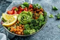 Buddha bowl salad with baked sweet potatoes, chickpeas, broccoli, tomatoes, greens, avocado, pea sprouts on light blue background Royalty Free Stock Photo