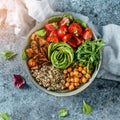 Buddha bowl salad with baked sweet potatoes, chickpeas, quinoa, tomatoes, arugula, avocado, sprouts on light blue background Royalty Free Stock Photo