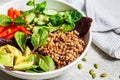 Buddha bowl salad with buckwheat, vegetables and seeds in white plate