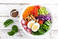 Buddha bowl salad with chickpeas, sweet pepper, tomato, cucumber, red cabbage kale, fresh radish, spinach leaves and boiled egg Royalty Free Stock Photo