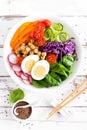 Buddha bowl salad with chickpeas, sweet pepper, tomato, cucumber, red cabbage kale, fresh radish, spinach leaves and boiled egg Royalty Free Stock Photo