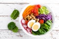 Buddha bowl salad with chickpeas, sweet pepper, tomato, cucumber, red cabbage kale, fresh radish, spinach leaves and boiled egg Royalty Free Stock Photo