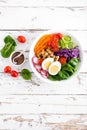 Buddha bowl salad with chickpeas, sweet pepper, tomato, cucumber, red cabbage kale, fresh radish, spinach leaves and boiled egg Royalty Free Stock Photo