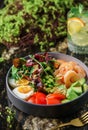 Buddha bowl salad with shrimps, arugula, spinach, avocado, tomatoes, green edamame beans, eggs on marble background. Healthy salad Royalty Free Stock Photo