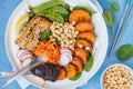 Buddha bowl vegan salad with vegetables, tofu, baked sweet potato, sprouts chickpeas and hemp dressing. Royalty Free Stock Photo