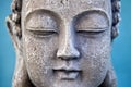 Buddha face on blue background. Close up. Royalty Free Stock Photo