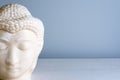 Buddha face. Buddha statue made of white marble with free space for text. Concept of peace, calm and tranquility