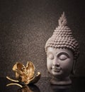 Buddha head statue and golden orchid flower. Royalty Free Stock Photo