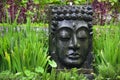 Buddha image with falling water in the tropical garden in Ubud, Bali.