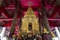 Buddha image in golden pagoda at the main hall of Wat Prathat Lampang Luang, an ancient Buddhist temple in Lampang, Thailand.