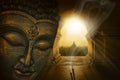 Buddha image meditating between incense sticks