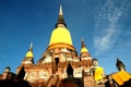 Buddha statue at the bottom of ancient pagoda on blue sky background at Wat Yai Chaimongkol, Ayutthaya, Thailand Royalty Free Stock Photo