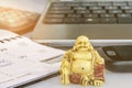 Buddha statue in front of office equipment symbolizing stress reduction and mindfulness