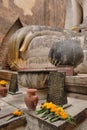 Buddha statue hand and offerings at Wat Si Chum in Sukhothai Historical Park. Thailand Royalty Free Stock Photo