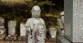 Buddha, statue in Japan graveyard with child for safety, protection and sculpture outdoor in nature. Jizo, tombstone and Royalty Free Stock Photo