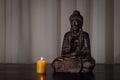 Buddha statue and lit candle Royalty Free Stock Photo