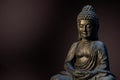 Buddha statue sitting in meditation pose against deep dark background. Royalty Free Stock Photo