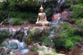 Buddha statue sitting in a river with rocks and green moss Royalty Free Stock Photo