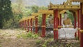 Buddha Statues in a green field at the base of Mount Zwegabin near Hpa-An, Myanmar.