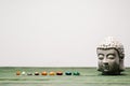 Buddha statuette and colorful semiprecious stones on wooden surface