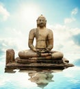 Buddha stone statue with water reflection.