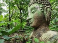 Buddha vestige in green nature at Wat Umong, Chiang Mai, Thailand, green buddha portrait covered with moss