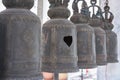 The Buddhism religious bell. Hole on iron bell among other bell. Royalty Free Stock Photo