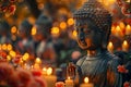 Buddhist Buddha statue surrounded by lit candles and fresh flowers on Wesak or Vesak Day