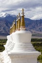 Buddhist chortens, white stupa and Himalayas mountains in the background near Shey Palace in Leh in Ladakh, India Royalty Free Stock Photo