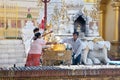 Buddhist family devotees pours water to statue of