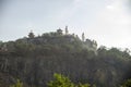 Buddhist giant statue on a massive hill with old buildings and churches