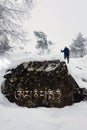 Buddhist mantra. Large stone with the inscription on Tibetan - Om mani padme hum, and silhouette of a pilgrim in the background. Royalty Free Stock Photo