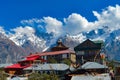 A Buddhist Monastery against show covered mountain with floating clouds in the background. Kaza Himachal Pradesh India South Asia