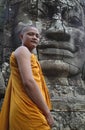 Angkor Wat, Cambodia, Buddhist monk and giant stone face Royalty Free Stock Photo