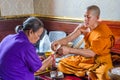 Buddhist monk blessing disciple in the Temple Wat Traimit, Bangkok