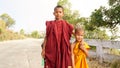 Buddhist Monk Children walking down on an empty road at the Kyaiktiyo Golden Rock Pagoda in near Yangon, Burma