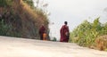 Buddhist Monk Children walking down on an empty road at the Kyaiktiyo Golden Rock Pagoda in near Yangon, Burma