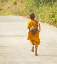 Buddhist Monk Children walking down on an empty road at the Kyaiktiyo Golden Rock Pagoda in near Yangon, Burma