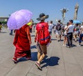 Buddhist monk and Chinese man walking in Tienanmen Square in China