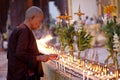 Buddhist monk lighting candles