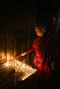 Buddhist monk lights a  candle Royalty Free Stock Photo