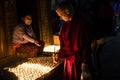 Buddhist monk lights a candle