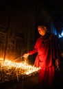 Buddhist monk lights a candle