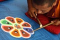 Buddhist monk making sand mandala.