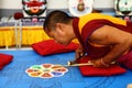 Buddhist monk making sand mandala.