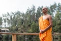 buddhist monk in orange kasaya looking