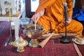 Monk do holy water. close up of Buddhist monk`s hand pouring melt candle tears to the water for making blessing water in Thai wedd