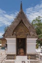 Buddhist monk prays kneeling in a shrine inside the Wat Xieng Thong temple in Luang Prabang, Laos